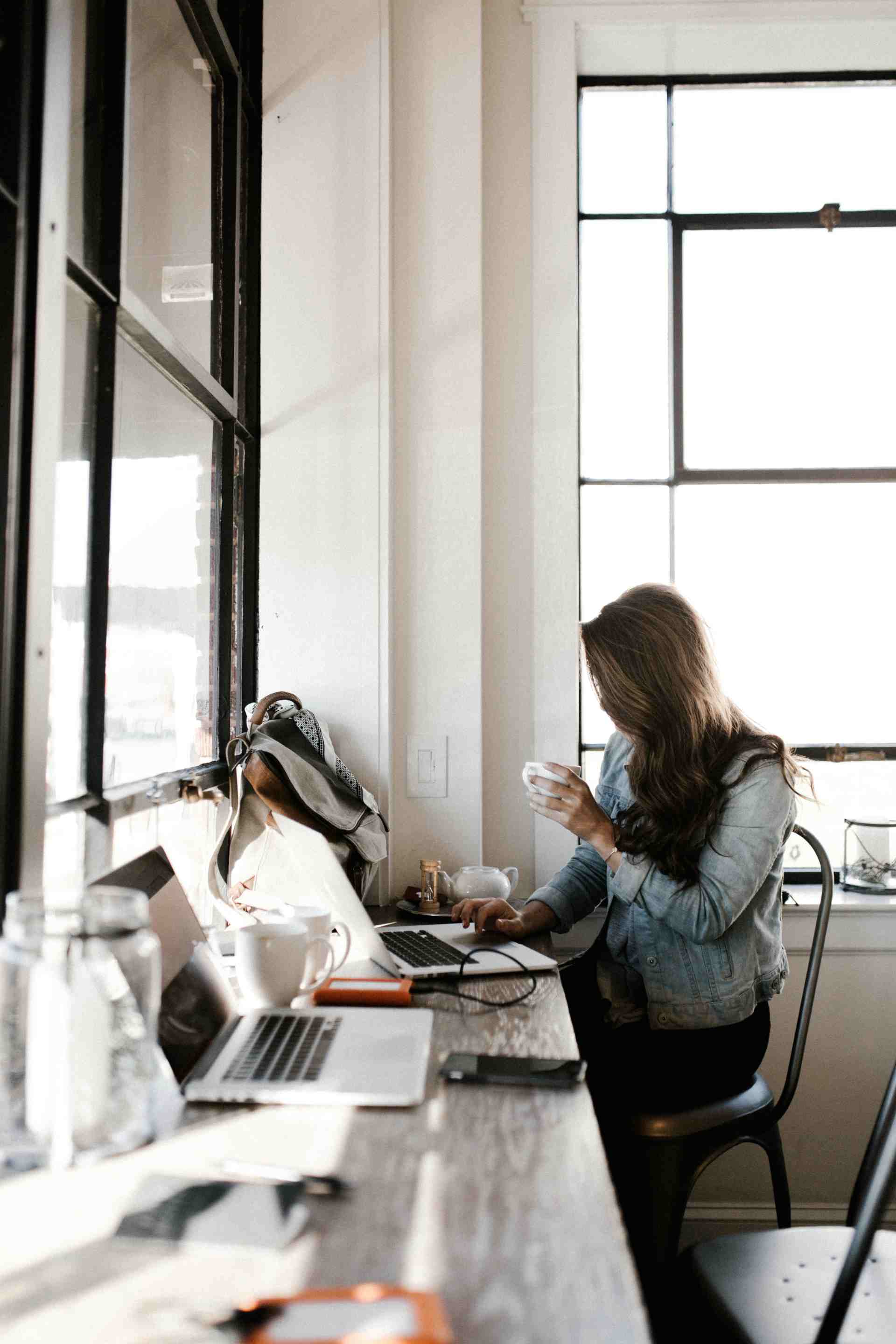 Professional woman drinking coffee and working on her laptop